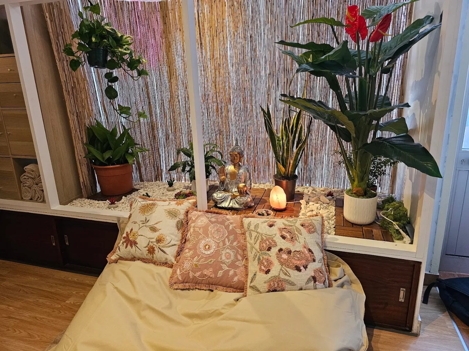 Canto zen com estátua de Buda, plantas, pedras brancas e lâmpada de sal